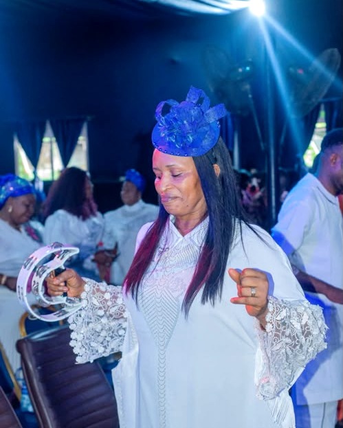 Prophetess Idongesit Archibong worshipping in white attire and a blue headpiece